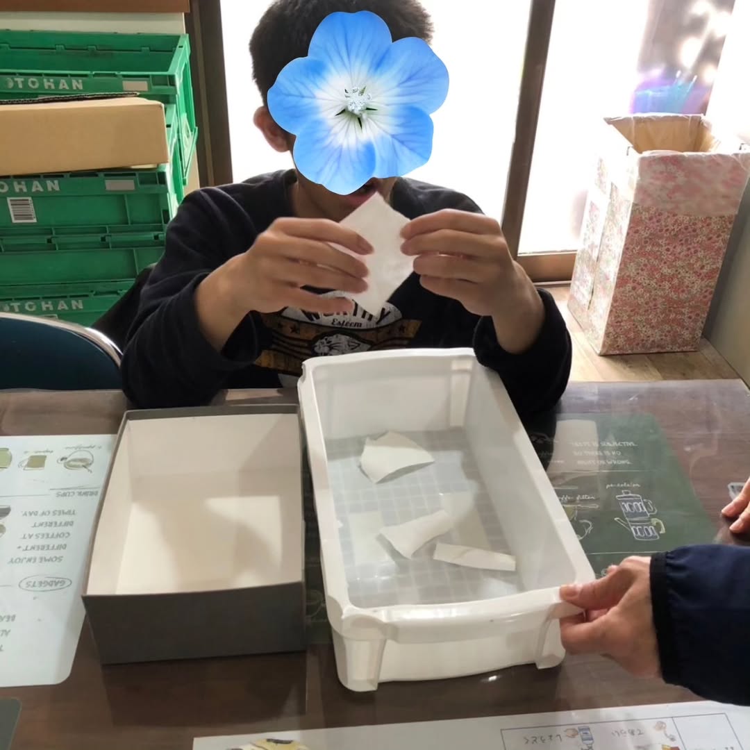 牛乳パックをちぎって水に浸す様子