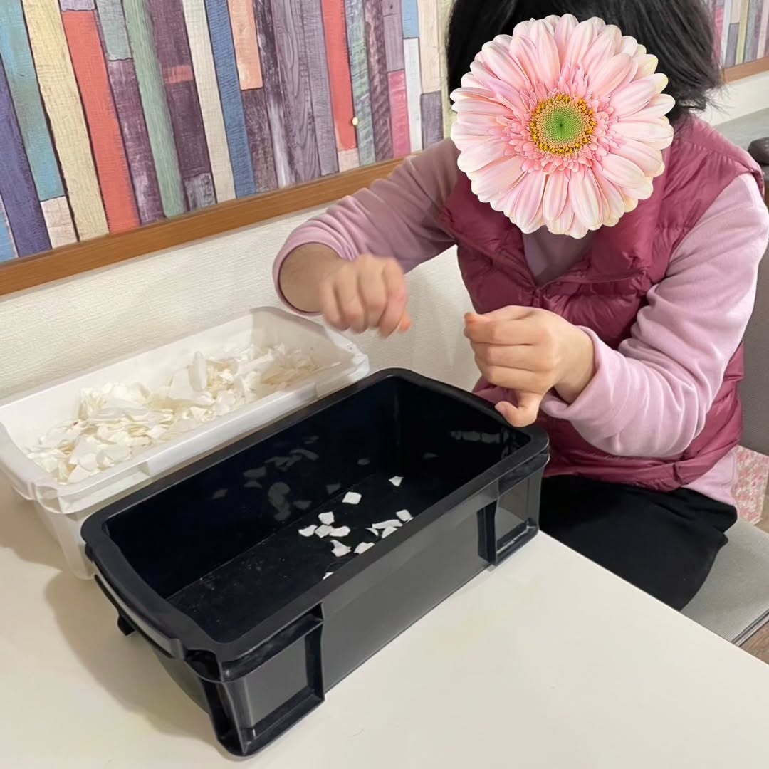 牛乳パックをちぎって水に浸す様子